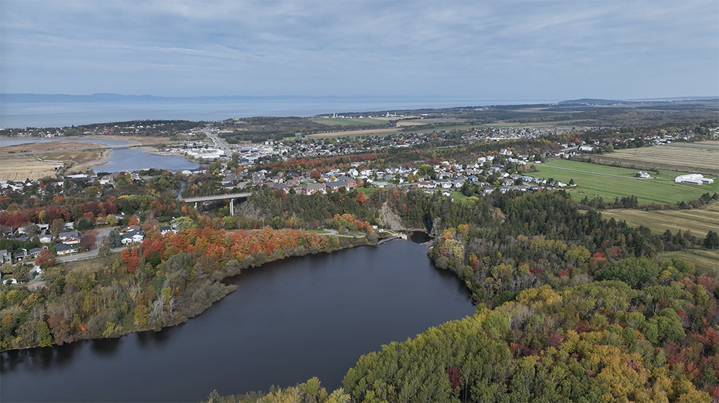 Analyse aérienne par drone d’un territoire combinant zones urbaines, naturelles et infrastructures pour une planification adaptée.