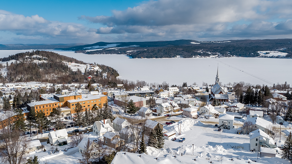 Vue aérienne par drone d’un village en hiver démontrant l’adaptation des captations aux conditions climatiques et saisonnières.